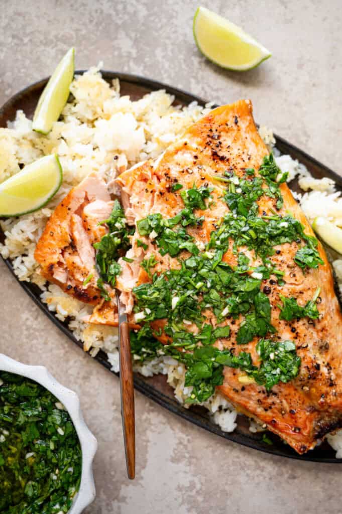 broiled salmon with salsa verde on a bed of crispy rice.