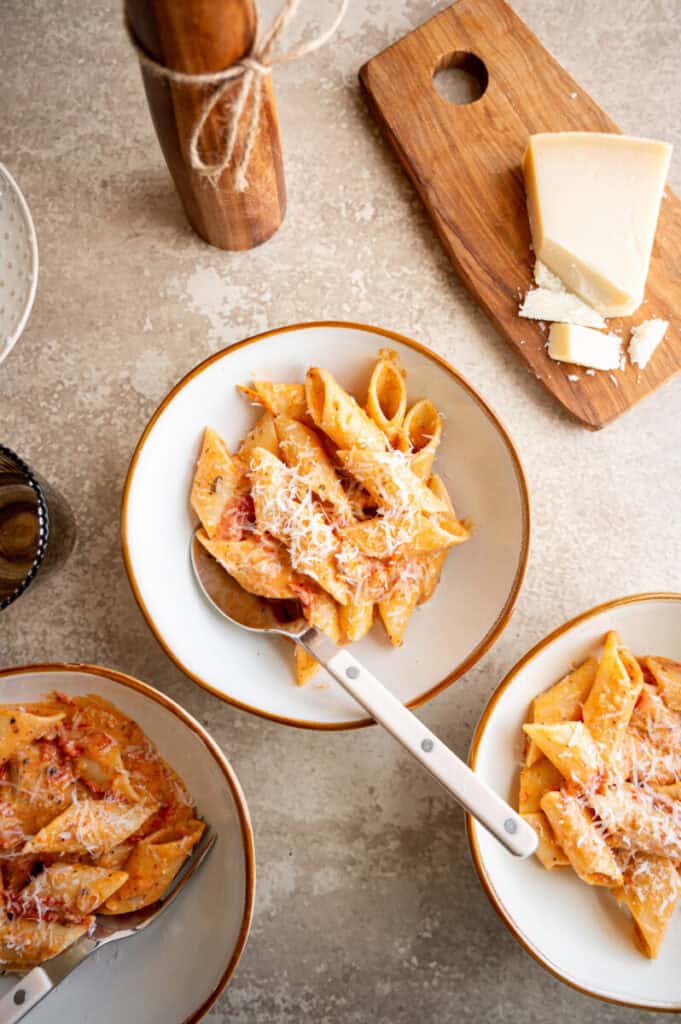 tomato penne pasta in a bowl with a spoon.