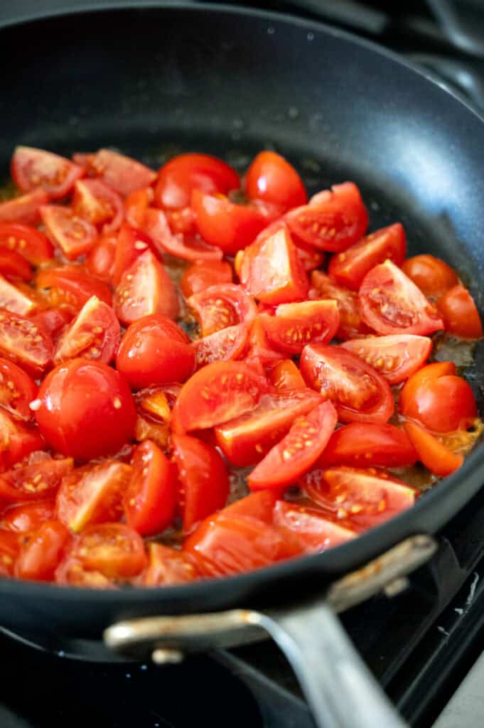 tomatoes cooking in a pan.