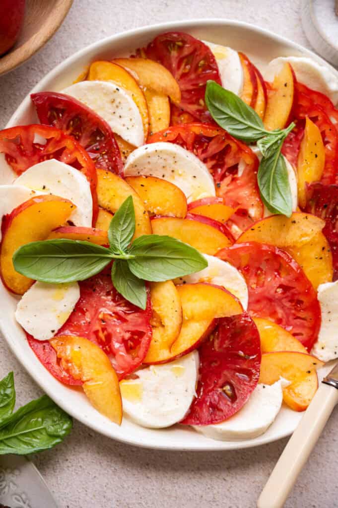 caprese salad with peaches on a plate.