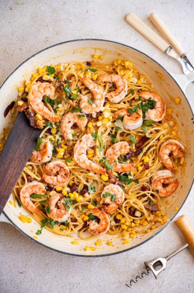 Corn and shrimp carbonara in a skillet.