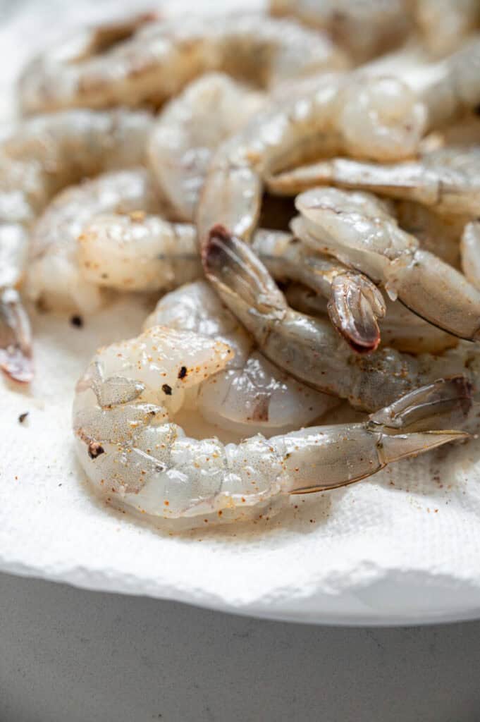 raw seasoned shrimp on a plate.