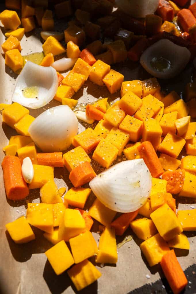 butternut squash, carrot, and onion on a baking sheet.