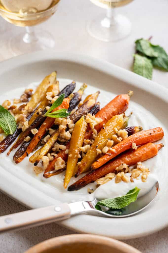 close up shot of roast carrots with yogurt and walnuts.