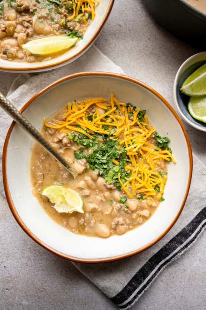 white turkey chili in a bowl with a spoon.