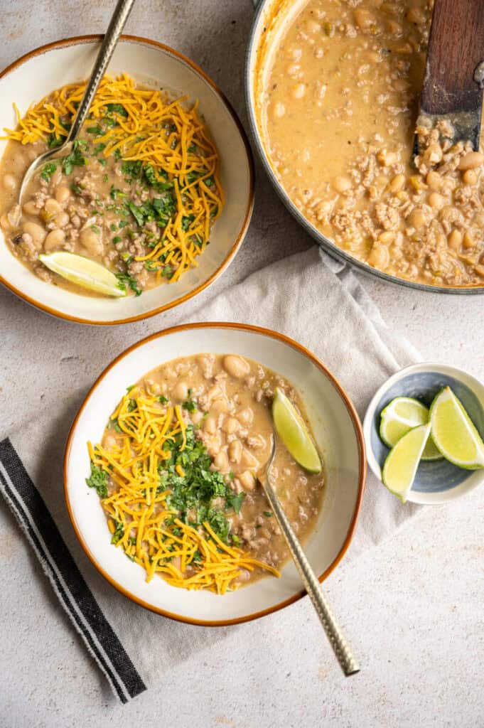 white turkey chili in a bowl with cheese and cilantro.