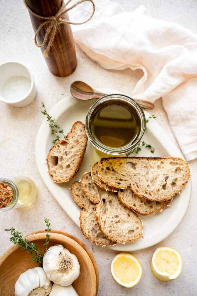 garlic infused olive oil on a plate with bread.