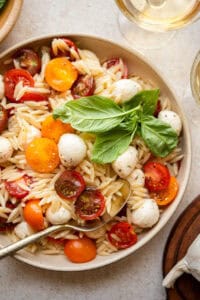 caprese orzo in a bowl with fresh basil.