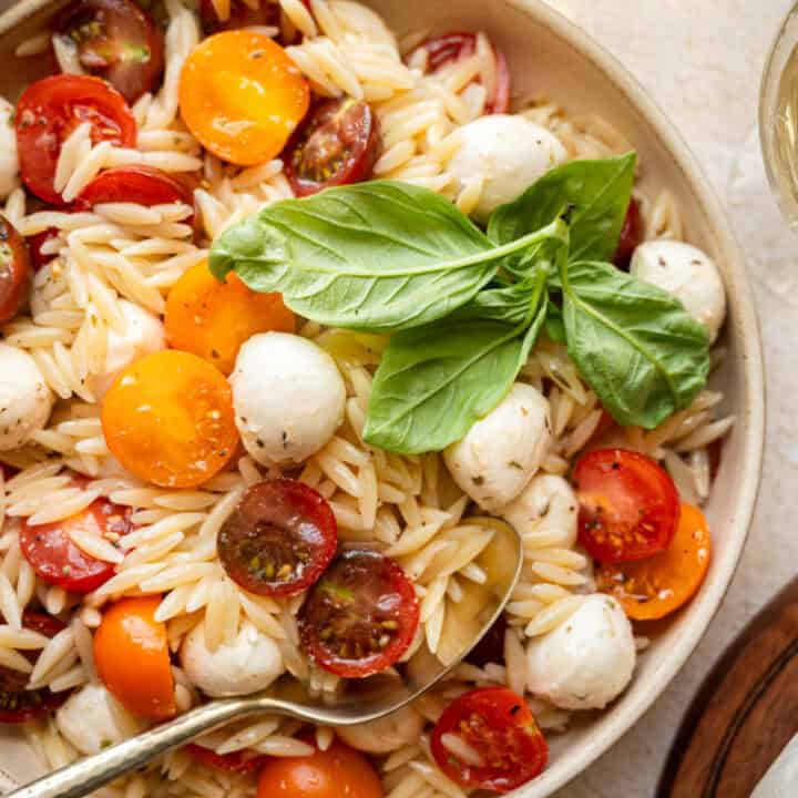 caprese orzo in a bowl with fresh basil.