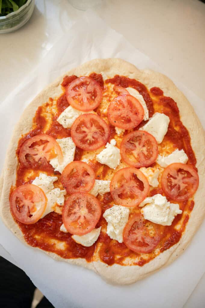 pizza with sauce, mozzarella, and sliced tomato.