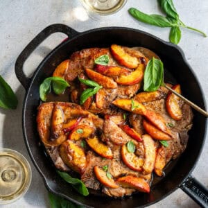 pork chops and peaches in a skillet.