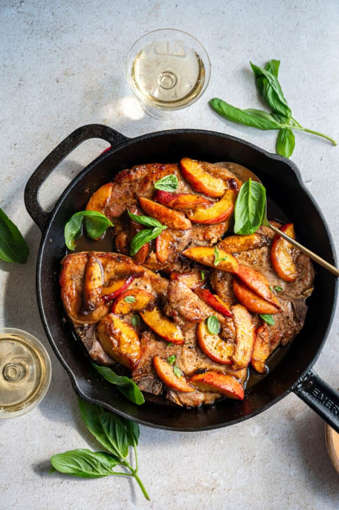 pork chops and peaches in a skillet.