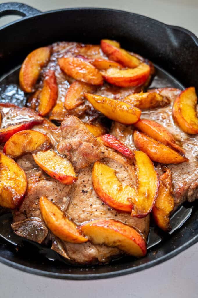 pork chops and peaches in a skillet.