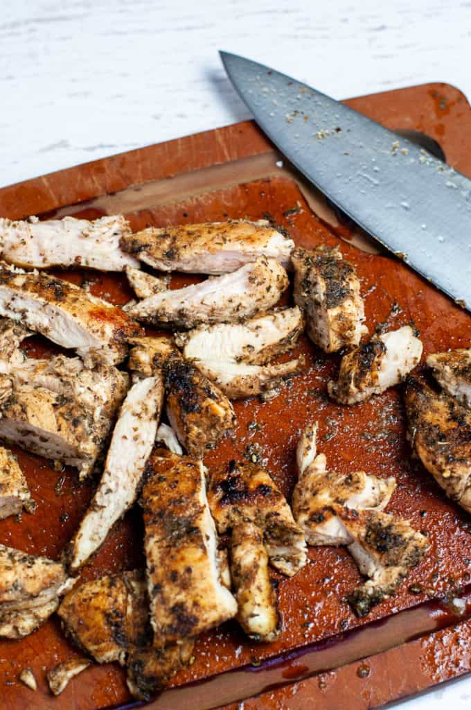 Greek seasoned chicken on a cutting board