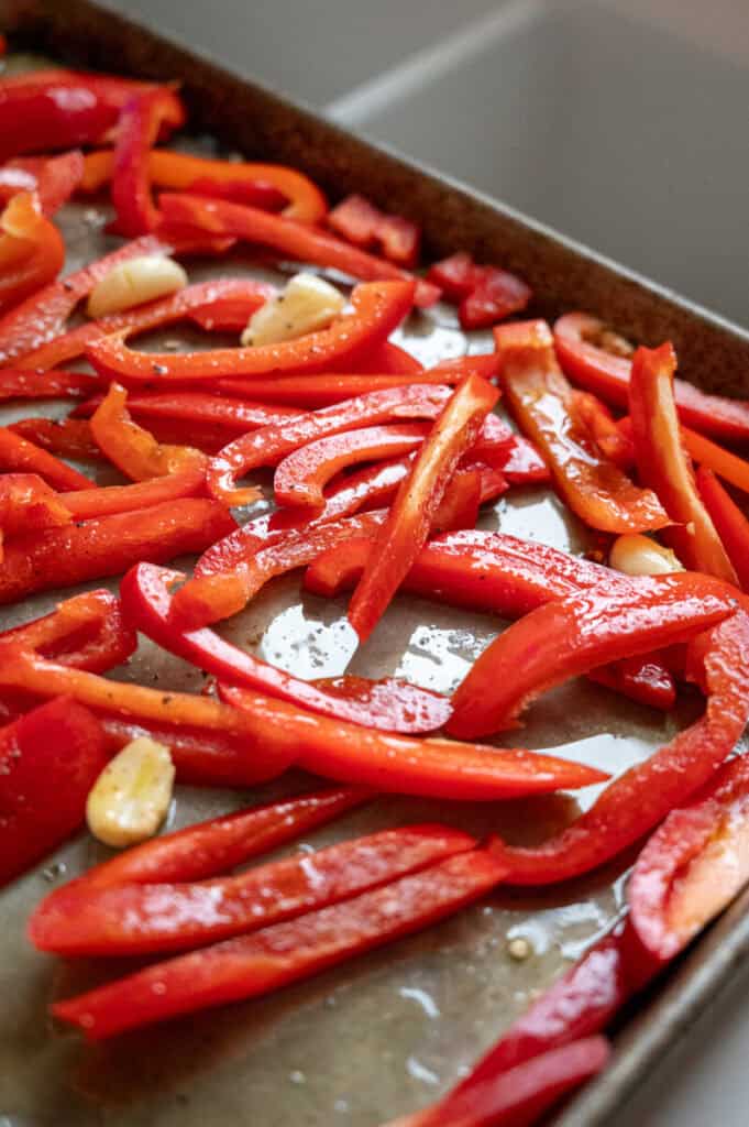 red peppers and garlic on a sheet pan.
