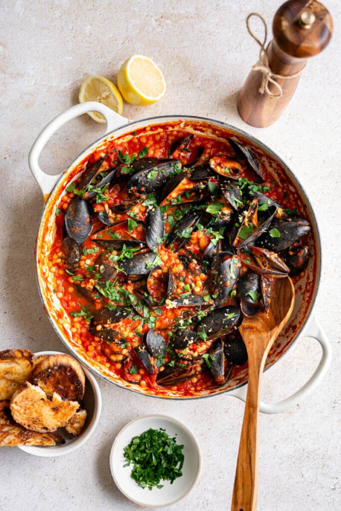 mussels with couscous and bread in a skillet.