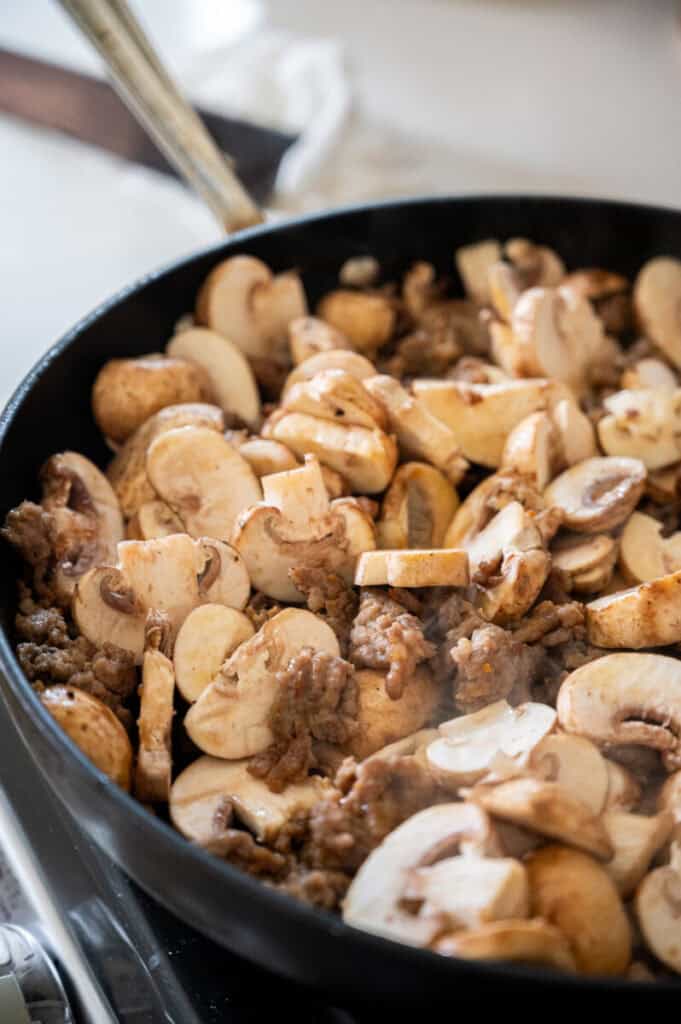 sausage and mushrooms in a skillet.