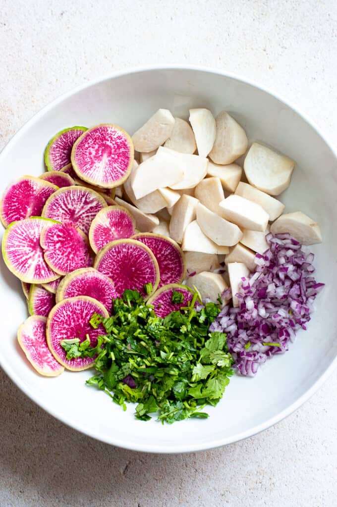 Radishes, cilantro, and herbs in a bowl