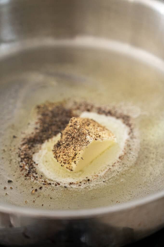 black pepper toasting in a pan.