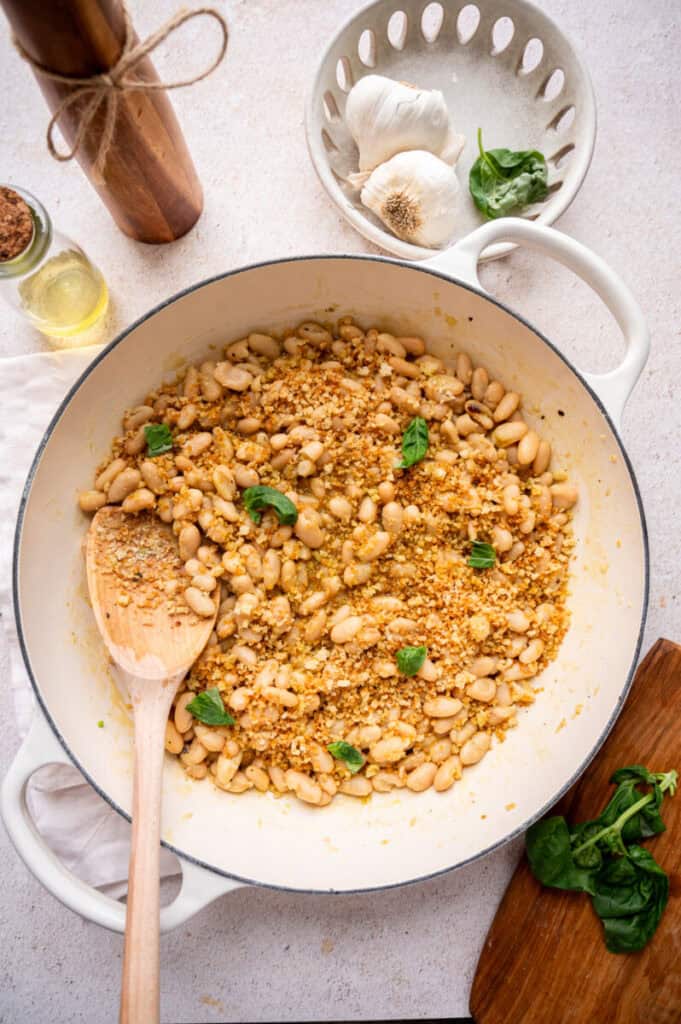cannellini beans in a pan with breadcrumbs and basil.
