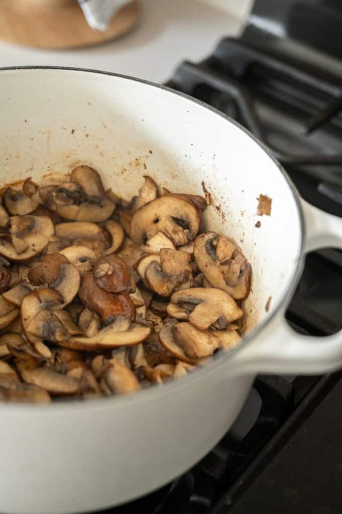 mushrooms sauteeing in a pot.