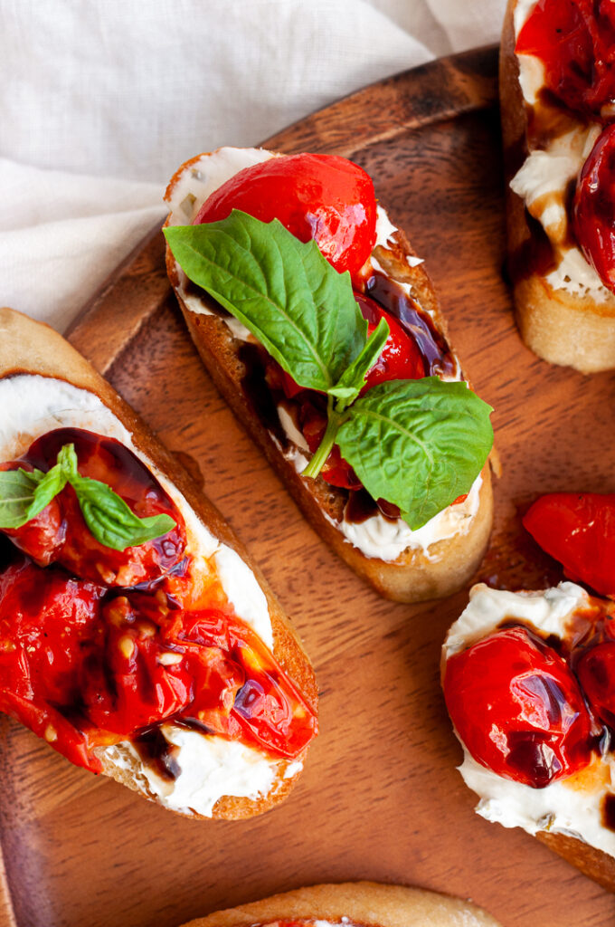 Tomato on crostini with cream cheese and basil