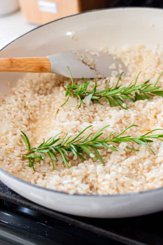 risotto and rosemary in a pan
