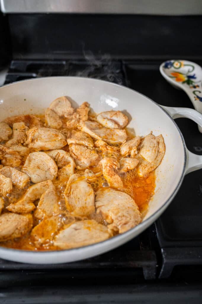 chicken cooking in a skillet.