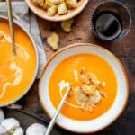 Roasted Red Pepper and Gouda Soup in a bowl with a spoon