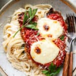Chicken Parmesan Alfredo in a gold bowl with wooden silverware