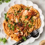 blackened cajun salmon pasta on a white plate