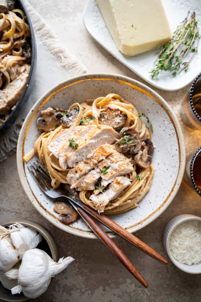 chicken marsala fettuccine Alfredo in a bowl with a fork.