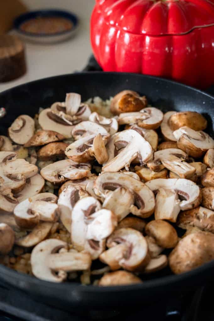 mushrooms sauteeing in a pan.
