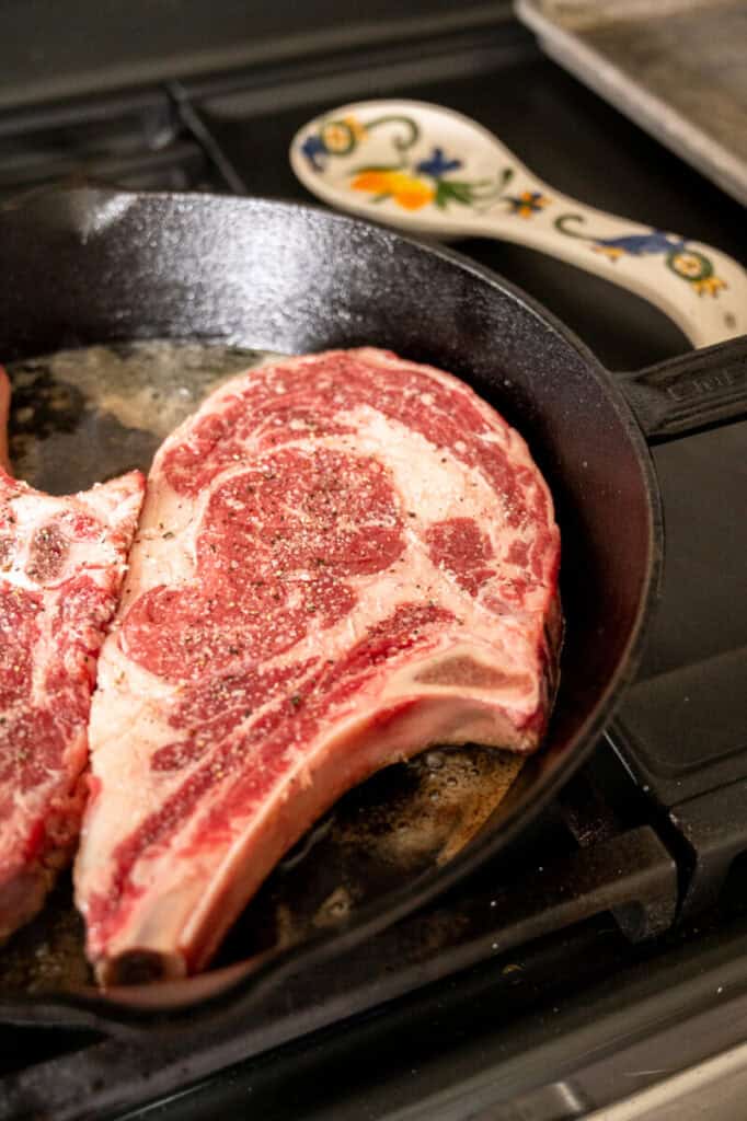 bone in ribeye in a pan.