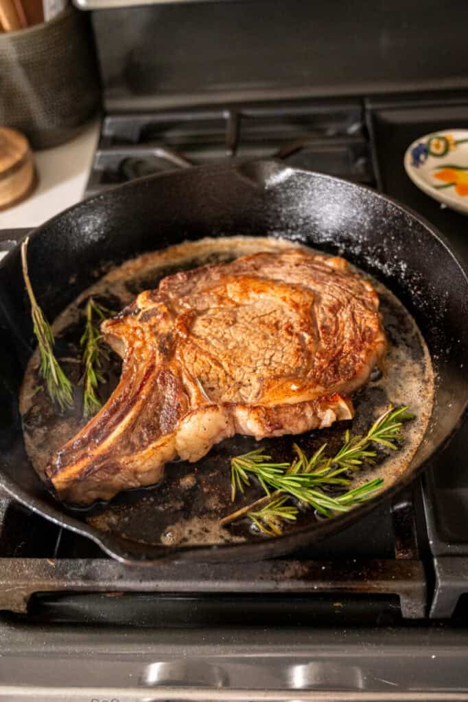 ribeye cooking with rosemary and butter.