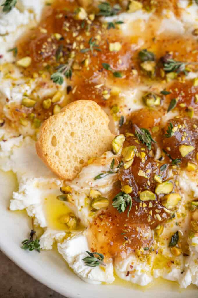 cracker dipping in goat cheese appetizer.
