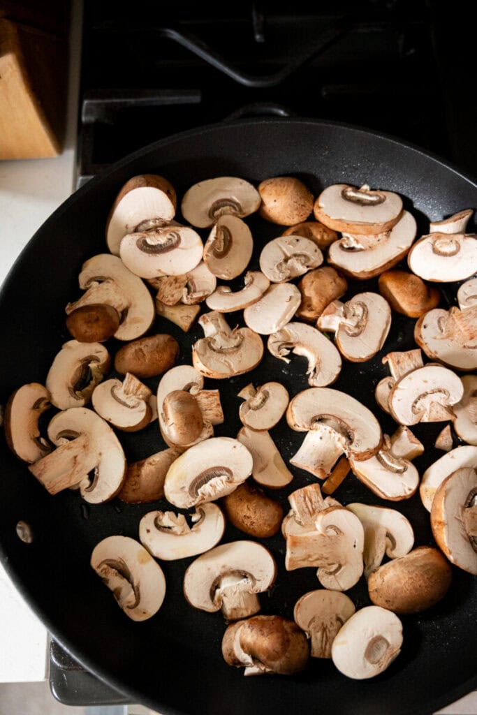mushrooms sautéing in a pan.