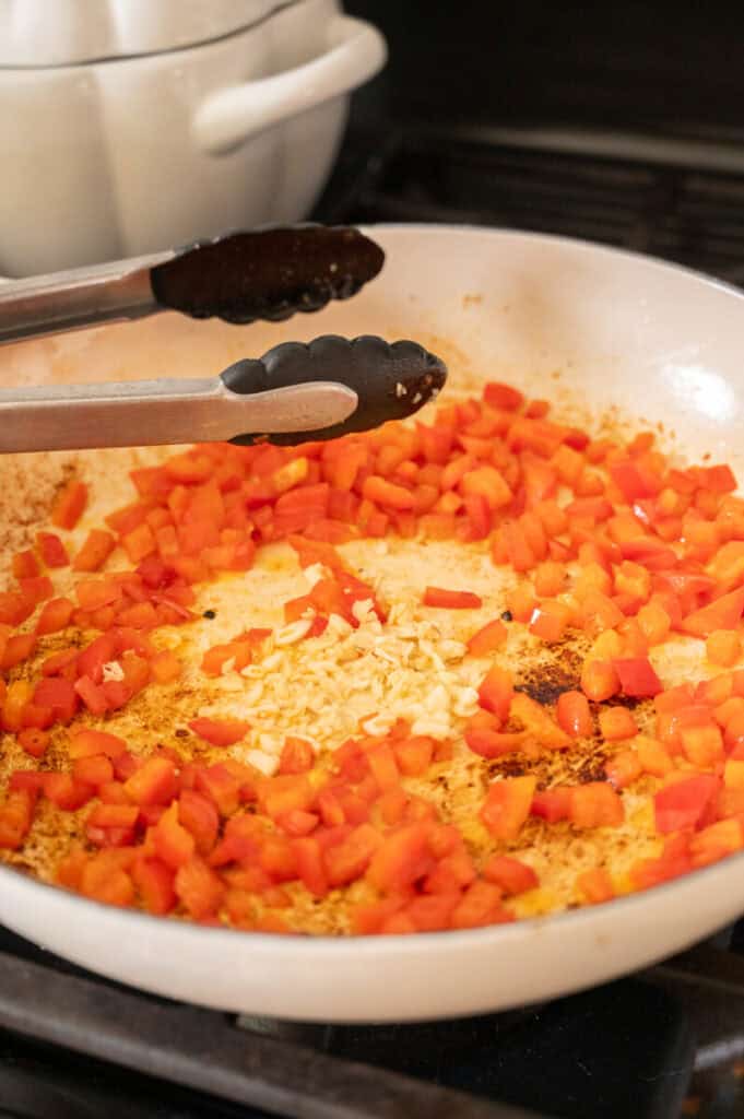 red peppers cooking in a skillet.