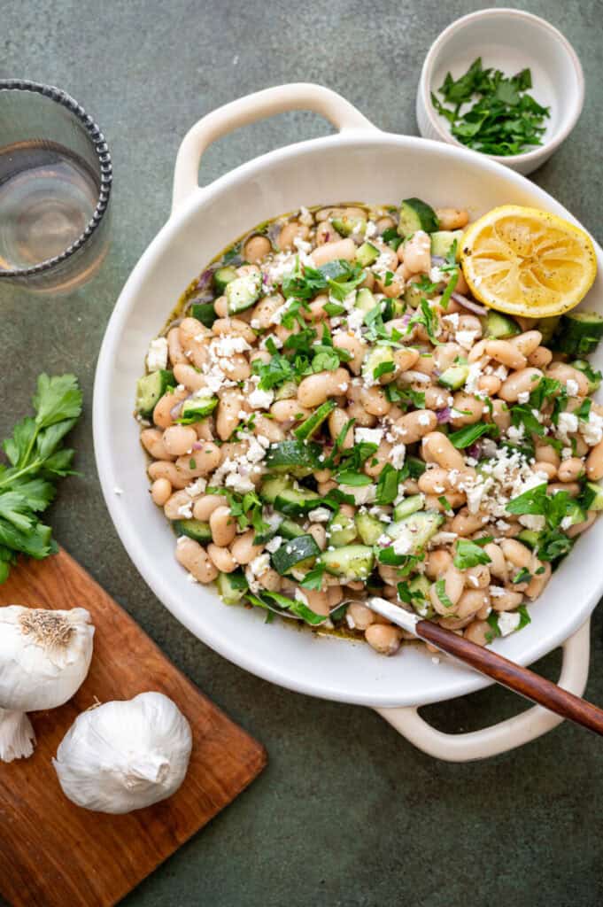 cannellini bean salad in a bowl with a spoon.
