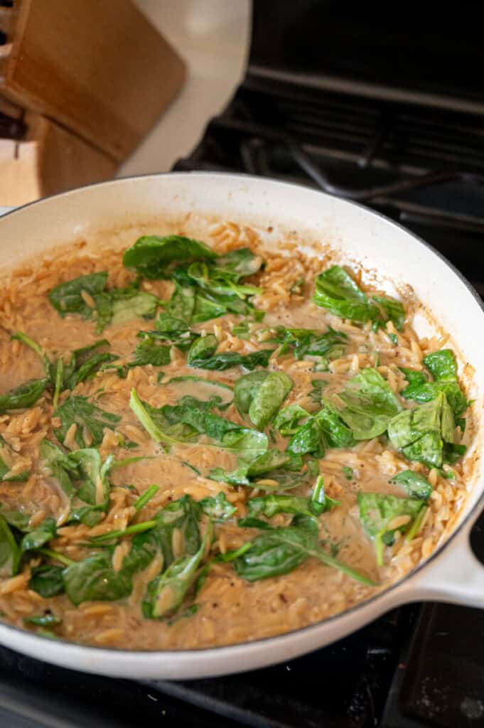 creamy spinach orzo in a pan.