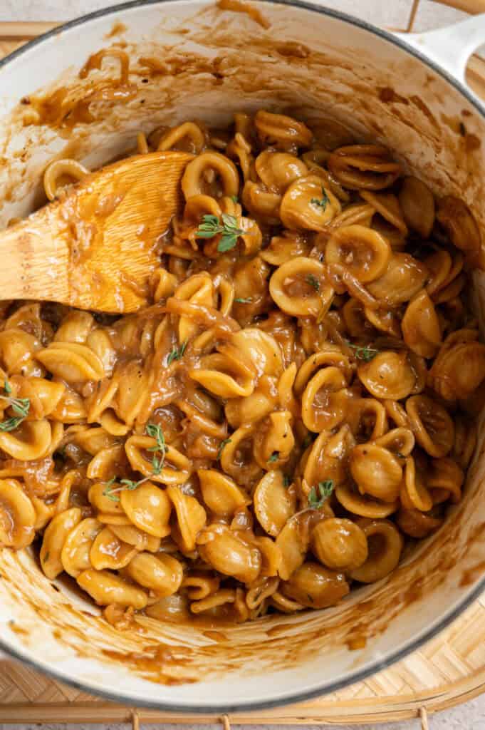 close up shot of French onion pasta with thyme.