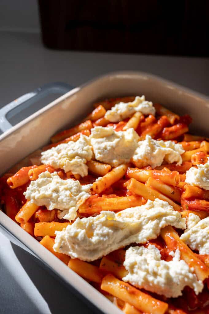 ziti in a baking dish with ricotta.